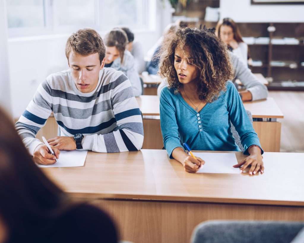 A student glancing at someone else’s test during an exam, symbolising the habit of focusing on others instead of staying grounded in your own life.